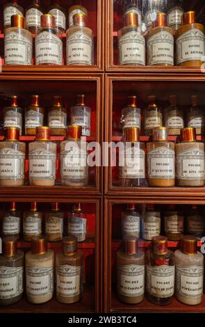 Beaune, France - 16 août 2023 : pharmacie armoire en bois de l'hôpital historique de Beaune - ingrédients pour la préparation des médicaments. Bouteilles sur la she Banque D'Images