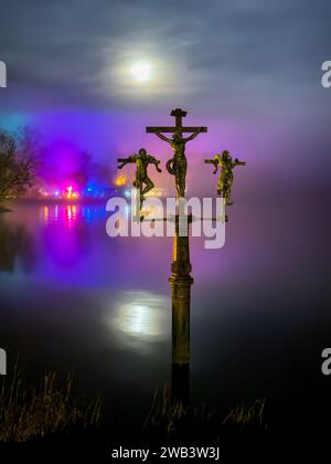 Mainau, Allemagne - 27 décembre 2023 : statue historique de crucifixion et un jardin de Noël, événement annuel avec de belles créations lumineuses et illumina Banque D'Images