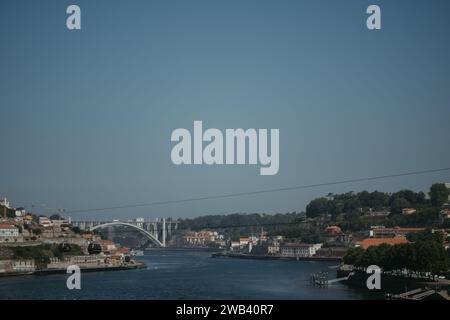 Une vue aérienne d'une rivière, avec deux petites maisons situées à proximité, en toile de fond d'une grande ville Banque D'Images