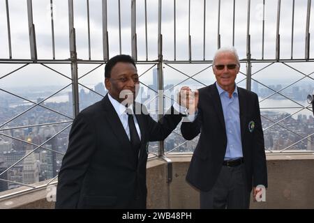 New York, États-Unis. 17 avril 2015. Les légendes du football Pele et Franz Beckenbauer (à droite) se tiennent debout sur l'Empire State Building et se tiennent la main. Les deux anciens joueurs du Cosmos de New York ont allumé les lumières du plus haut bâtiment du monde en vert vendredi en l'honneur de leur ancien club. Franz Beckenbauer est mort. La légende allemande du football est morte dimanche à l'âge de 78 ans, a déclaré lundi sa famille à l'Agence de presse allemande. Crédit : Picture alliance/dpa/Alamy Live News Banque D'Images