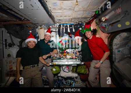 ISS - 25 décembre 2023 - quatre membres d'équipage de l'expédition 70 se rejoignent dans le module Unity de la Station spatiale internationale pour un repas le jour de Noël. Banque D'Images