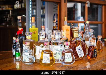 Bouteilles d'alcool et spiritueux dans un bar restaurant. L'alcool en bouteille est présenté sur l'étagère. Variété d'étiquettes importées et domestiques, marques et suppli Banque D'Images