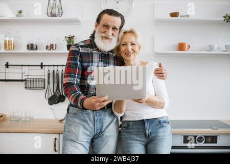 Portrait d'heureux vieux couple marié magasinant en ligne pour le délicieux petit déjeuner. Banque D'Images