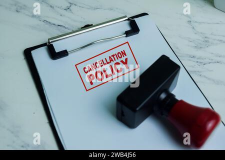 Tampon en caoutchouc de poignée rouge et texte d'annulation au-dessus de la paperasse isolé sur fond en bois Banque D'Images