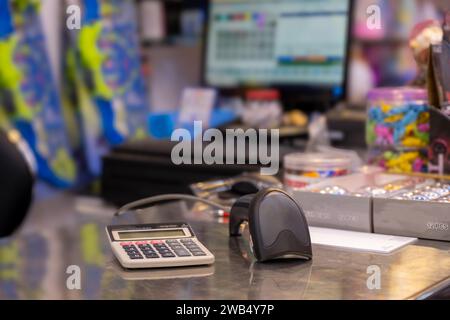 Scanner de code QR sur la table avec calculatrice avec écran de cajou en arrière-plan dans la librairie Banque D'Images