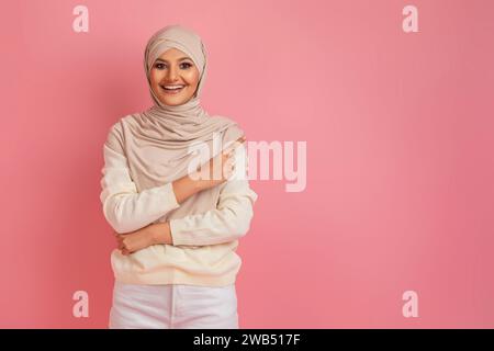 Belle offre. Heureuse femme musulmane dans le hijab pointant de côté à Copy Space Banque D'Images