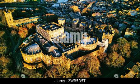 Vue aérienne d'un majestueux château médiéval de Lancaster au coucher du soleil, avec la verdure environnante et la ville en arrière-plan. Banque D'Images