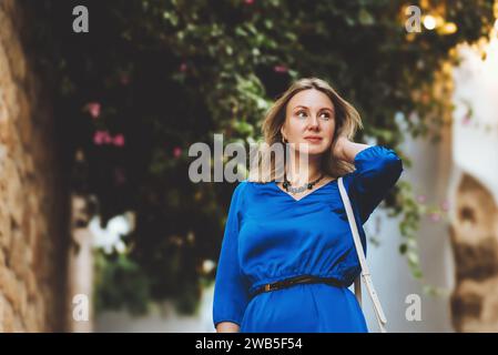 Touriste féminine dans une robe bleue dans la rue de Lindos en Grèce. Banque D'Images