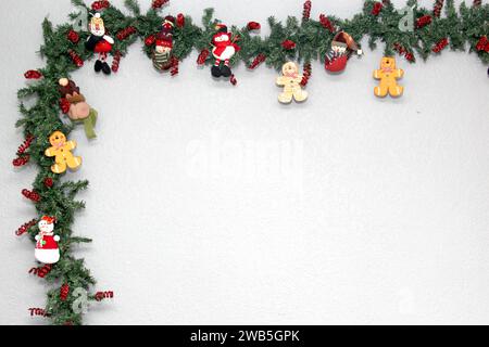 Père noël, bonhomme de neige et biscuit de pain d'épice dans la couronne de noël avec fond gris, décoration de noël Banque D'Images
