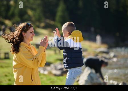 Une mère et son fils créent des souvenirs chéris alors qu'ils s'engagent de manière ludique dans des activités de plein air, leurs rires faisant écho à la joie des moments partagés et de la Banque D'Images