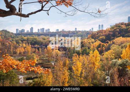 Vue d'automne depuis la colline sur Weston Family Quarry Garden, une partie du site historique Valley Brick Works, avec des silhouettes brumeuses de hauts immeubles du centre-ville Banque D'Images