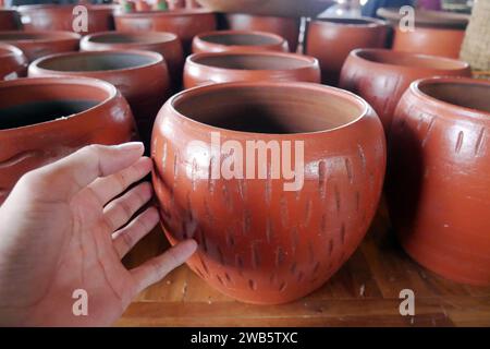 Cruches en terre cuite en argile céramique faites à la main, pots, vases, souvenirs sur des étagères dans la boutique de poterie artisanale de rue. Pot en céramique brun argile Banque D'Images