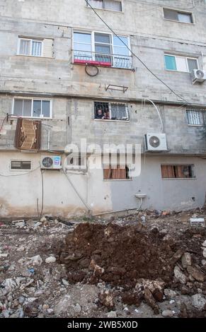 Tulkram, Tulkram, Palestine. 8 janvier 2024. Une famille observe l'état de leur maison dans le camp de réfugiés de Nur Shams à Tulkarem, en Cisjordanie. (Image de crédit : © Bruno Gallardo/ZUMA Press Wire) USAGE ÉDITORIAL SEULEMENT! Non destiné à UN USAGE commercial ! Crédit : ZUMA Press, Inc./Alamy Live News Banque D'Images