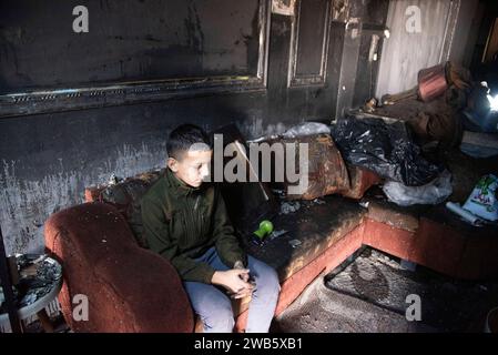 Tulkram, Tulkram, Palestine. 8 janvier 2024. Un garçon est assis dans le salon de sa maison, quelques jours après avoir reçu une grenade dans le camp de réfugiés de Nur Shams, à Tulkram, en Cisjordanie. (Image de crédit : © Bruno Gallardo/ZUMA Press Wire) USAGE ÉDITORIAL SEULEMENT! Non destiné à UN USAGE commercial ! Crédit : ZUMA Press, Inc./Alamy Live News Banque D'Images