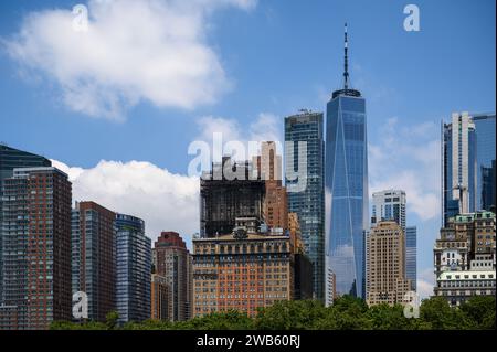 Détail des immeubles de bureaux et du One World Trade Center dans le quartier financier de New York avec ciel ensoleillé et bleu et nuages. Banque D'Images