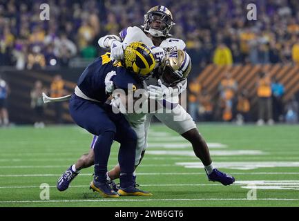 Houston, États-Unis. 08 janvier 2024. Blake Corum, le second running des Michigan Wolverines, est attaqué par une paire de Washington Huskies au premier quart-temps lors du championnat national des éliminatoires de football universitaire 2024 au NRG Stadium de Houston, Texas, le lundi 8 janvier 2024. Photo de Kevin M. Cox/UPI crédit : UPI/Alamy Live News Banque D'Images