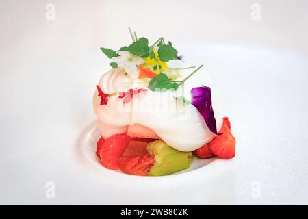 Dessert avec fraises, rhubarbe, pamplemousse, crème fouettée et fleurs fraîches dans un restaurant alsacien winstub Colmar, Alsace, France Banque D'Images