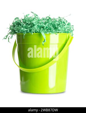 Papier herbe de Pâques dans un seau en plastique vert. Panier cadeau aux couleurs vives et froissé déchiqueté pour le remplissage et la décoration, fourré dans le seau. Banque D'Images