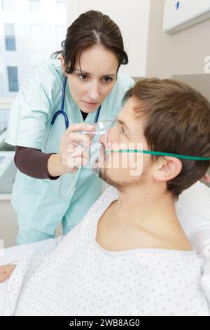 infirmière plaçant le masque d'oxygène sur le patient à l'hôpital Banque D'Images