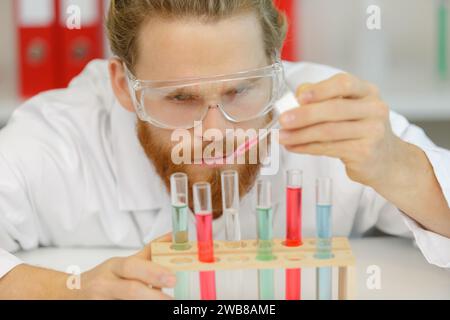 Jeune biologiste définit le séquençage d'Adn réaction avec pipette multicanaux Banque D'Images