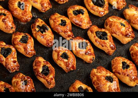 Pâtisserie aux olives. Biscuits aux olives fraîchement cuits sur un fond blanc Banque D'Images