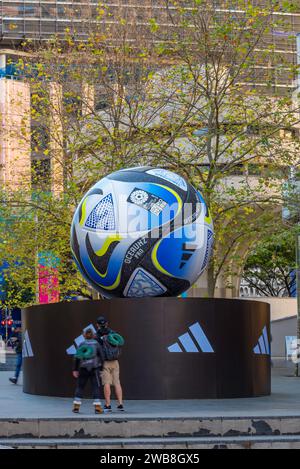 Des personnes regardant un ballon géant de la coupe du monde féminine de la FIFA 2023 monté sur une plate-forme Adidas à Martin place, Sydney, Australie Banque D'Images