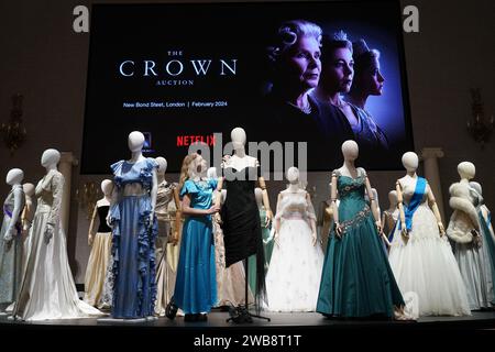 Une assistante de galerie ajuste une reproduction de la robe de revanche de la princesse Diana, qui fait partie de la collection de plus de 450 costumes, décors et accessoires de la série Netflix The Crown, présentée à Bonhams dans le centre de Londres, avant d'être vendue aux enchères le mois prochain. Date de la photo : mardi 9 janvier 2024. Banque D'Images