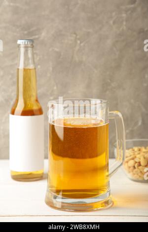 Verre de bière avec des cacahuètes sur fond gris. Vue de dessus Banque D'Images