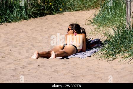Par un temps chaud glorieux à Dundee, les femmes locales prennent le soleil le long de la plage de Broughty Ferry pendant la canicule estivale en Écosse, au Royaume-Uni Banque D'Images