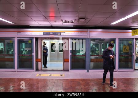 BUSAN, CORÉE DU SUD - 29 MARS 2023 : les gens montent à bord d'un train de métro à la station de métro Busan en Corée du Sud. Busan Metro a des portes de moustiquaire de plate-forme ( Banque D'Images