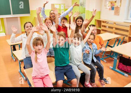 Portrait d'élèves joyeux hommes et femmes s'amusant avec l'enseignant dans la salle de classe à l'école Banque D'Images