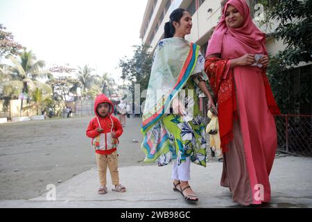 Les électeurs accompagnés de leur enfant se rendent au Donia College Polling Center à Dhaka pour voter, Bangladesh, 07 janvier 2024 Banque D'Images