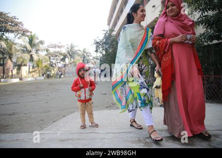 Les électeurs accompagnés de leur enfant se rendent au Donia College Polling Center à Dhaka pour voter, Bangladesh, 07 janvier 2024 Banque D'Images