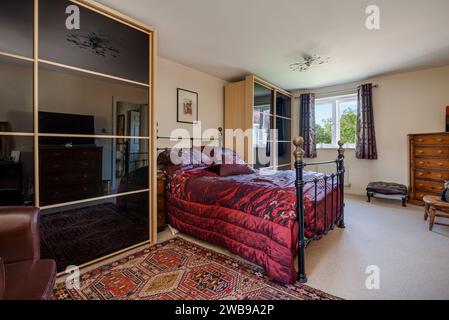 Cambridge, Angleterre - septembre 16 2015 : Chambre principale meublée avec couette rouge et armoires à miroirs Banque D'Images