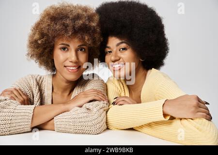 Frisés et jeunes amis afro-américains debout dans une tenue élégante sur fond gris, Juneteenth Banque D'Images