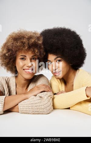 Deux amis afro-américains bouclés en tenue décontractée regardant la caméra sur fond gris, Juneteenth Banque D'Images