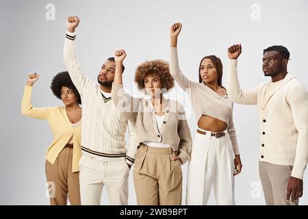 Juneteenth concept, peuple afro-américain heureux debout avec des poings serrés sur fond gris Banque D'Images