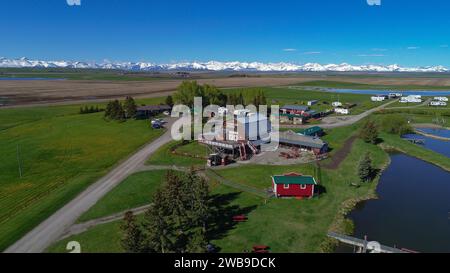 Vue panoramique sur un paysage magnifique avec une rivière sinueuse et de charmantes maisons nichées sur fond de majestueuse chaîne de montagnes Banque D'Images