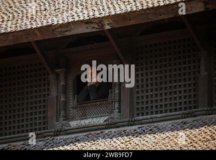 Lalitpur, Bagmati, Népal. 9 janvier 2024. Un touriste regarde depuis une fenêtre traditionnelle sur la place Patan Durbar, un site classé au patrimoine de l'UNESCO à Lalitpur, au Népal, le 9 janvier 2024. (Image de crédit : © Sunil Sharma/ZUMA Press Wire) USAGE ÉDITORIAL SEULEMENT! Non destiné à UN USAGE commercial ! Banque D'Images