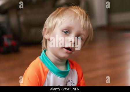 Portrait d'un tout-petit aux cheveux blonds, aux yeux bleus, curieux et impitoyable. Banque D'Images