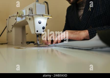 motif, ciseaux, mètre à ruban et machine à coudre. Lieu de travail de couturière. La couturière coupe le détail de la robe sur les lignes d'esquisse. Banque D'Images