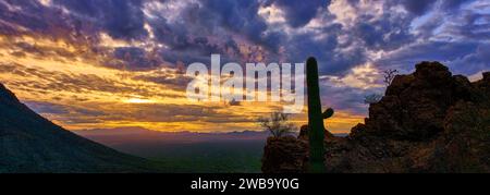 Le Gates Pass vista prend vie avec une silhouette saguaro dans un ciel spectaculaire après la tempête, peint par les couleurs vibrantes du coucher du soleil. Banque D'Images
