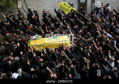 Khirbet Selm, Liban. 09 janvier 2024. Les partisans pro-iraniens du Hezbollah portent le cercueil du commandant en chef du parti, Wissam Tawail, lors de son cortège funèbre dans le village de Khirbit Selem, au sud du Liban. Tawil est le commandant le plus haut gradé du Hezbollah tué depuis le déclenchement du conflit transfrontalier entre Israël et le Hezbollah au Liban le 8 octobre, et le deuxième assassinat très médiatisé à avoir lieu au Liban en deux semaines. Crédit : Marwan Naamani/dpa/Alamy Live News Banque D'Images