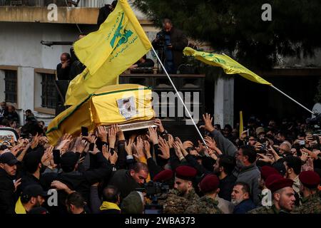 Khirbet Selm, Liban. 09 janvier 2024. Les partisans pro-iraniens du Hezbollah portent le cercueil du commandant en chef du parti, Wissam Tawail, lors de son cortège funèbre dans le village de Khirbit Selem, au sud du Liban. Tawil est le commandant le plus haut gradé du Hezbollah tué depuis le déclenchement du conflit transfrontalier entre Israël et le Hezbollah au Liban le 8 octobre, et le deuxième assassinat très médiatisé à avoir lieu au Liban en deux semaines. Crédit : Marwan Naamani/dpa/Alamy Live News Banque D'Images