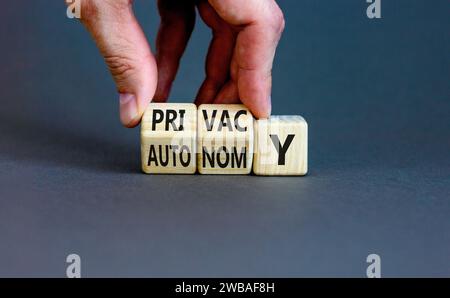 Symbole de confidentialité ou d'autonomie. Mot concept vie privée ou autonomie sur cubes en bois. Belle table grise fond gris. Main d'homme d'affaires. Confidentialité des affaires Banque D'Images