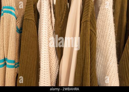 pulls et vestes en laine accrochés à des cintres dans un magasin de vêtements Banque D'Images