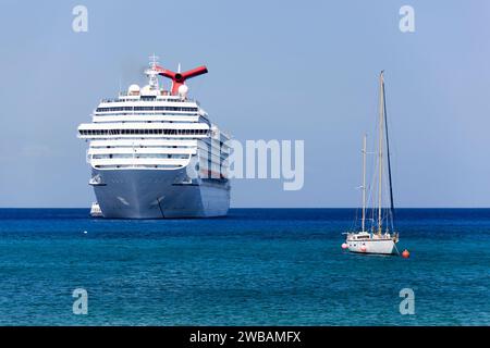 La vue matinale d'un bateau de croisière dérivant et d'un voilier près de Grand Cayman Shore (îles Caïmans). Banque D'Images