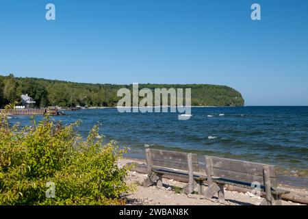 Bancs en bois à la plage sur la rive d'un beau lac par une journée ensoleillée avec un ciel bleu clair. Banque D'Images