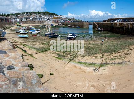 De petits bateaux échouent dans le port de Mousehole à marée basse Cornwall England Banque D'Images