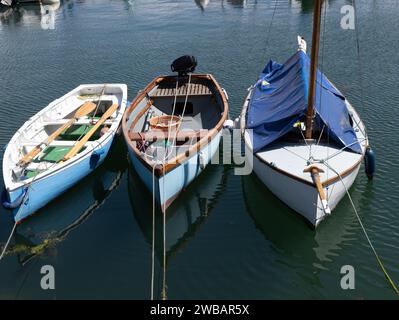 Trois bateaux traditionnels à rames et à voiles amarrés dans une rangée Banque D'Images